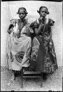 Seidou Keïta, Senza Titolo, 1952-55. Seidou Keïta, C.A.A.C. - The Pigozzi Collection, Ginevra [la foto rappresenta due amiche con stesse acconciature ed oggetti ornamentali tradizionali] 