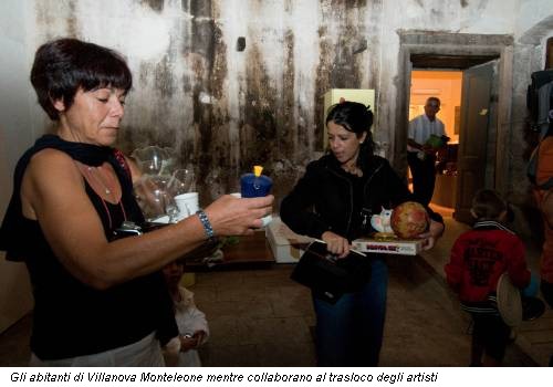 Gli abitanti di Villanova Monteleone mentre collaborano al trasloco degli artisti