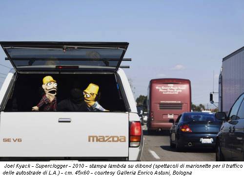 Joel Kyack - Superclogger - 2010 - stampa lambda su dibond (spettacoli di marionette per il traffico delle autostrade di L.A.) - cm. 45x60 - courtesy Galleria Enrico Astuni, Bologna