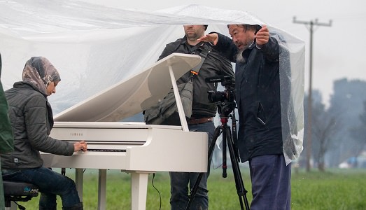 Concerto per piano in campo profughi, organizzato da dissidente. Ecco l’ultima “prova” umanitaria di Ai Weiwei, al confine tra Grecia e Macedonia