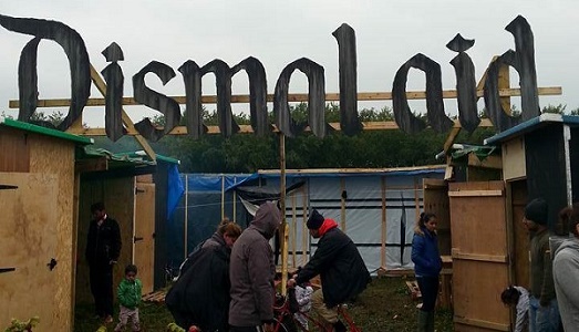 Dismaland di Banksy si trasforma in “Dismal Aid” a Calais. E qualcuno tenta di rubare l’insegna per venderla su ebay |