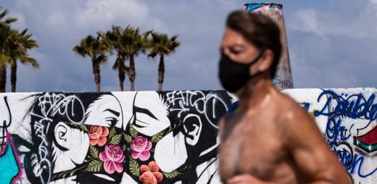 exibart.artworld: il giro del mondo dell’arte in sei notizie Una delle notizie dal mondo dell'arte di questa settimana è la racconta di street art a tema Coronavirus. Qui un'opera sul muro di una spiaggia a Los Angeles (Photograph: Étienne Laurent/EPA)