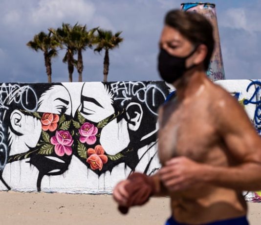 exibart.artworld: il giro del mondo dell’arte in sei notizie Una delle notizie dal mondo dell'arte di questa settimana è la racconta di street art a tema Coronavirus. Qui un'opera sul muro di una spiaggia a Los Angeles (Photograph: Étienne Laurent/EPA)