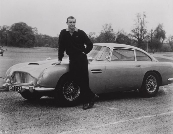 Goldfinger (1964) original photographic production still, US. Sean Connery e l'iconica Aston Martin DB5. Sotheby's
