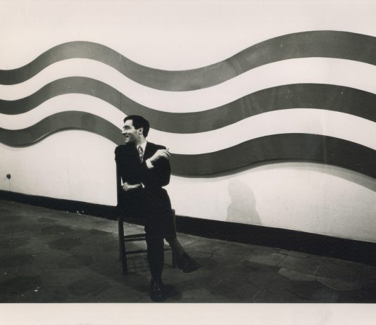 Bologna Art Week: le anticipazioni del fine settimana, tra gallerie e musei Sergio Lombardo seduto di fronte a Strisce ondulate extra, 1966. Courtesy Archivio Sergio Lombardo