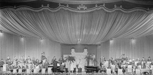 Sanremo è Sanremo. Alle Gallerie d’Italia di Torino la storia del Festival dagli anni cinquanta al 1976 Il Salone delle Feste del Casinò dove si sta svolgendo il IX Festival di Sanremo; i tavolini delle prime edizioni sono stati sostituiti con sedie per poter accogliere più persone, 1959. Fotografia di Nicola Giordano © Archivio Publifoto Intesa Sanpaolo