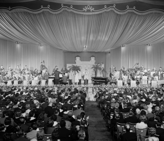 Sanremo è Sanremo. Alle Gallerie d’Italia di Torino la storia del Festival dagli anni cinquanta al 1976 Il Salone delle Feste del Casinò dove si sta svolgendo il IX Festival di Sanremo; i tavolini delle prime edizioni sono stati sostituiti con sedie per poter accogliere più persone, 1959. Fotografia di Nicola Giordano © Archivio Publifoto Intesa Sanpaolo