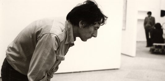 Giovanni Anselmo, naufrago all’orizzonte: l’ultima mostra al MAXXI di Roma Giovanni Anselmo durante l’allestimento della mostra “Identitè Italienne. L’art en Italie depuis 1959”, 1981, Parigi, Centre Pompidou. Foto: Nanda Lanfranco, Centro Archivi MAXXI Arte, Fondo Incontri Internazionali d’Arte. Courtesy: Fondazione MAXXI, 2024