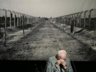 Kurt Julius Goldstein, survivor of the Nazi concentration camp Auschwitz, wipes away tears during his speech in front of a photo showing a way in the Nazi concentration camp Auschwitz, during a commemoration of the International Auschwitz Committee.
