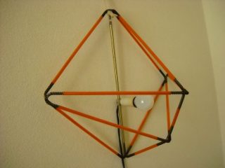 ...un critico commentava su CASAVOGUE -... per accendere la lampada di buccino occorre un'altra lampada! Infatti era fluorescente alla luce Wood, struttura d'acciaio, nodi spaziali in filo armonico brunito, portalampada in duralluminio a blocco esagonale c