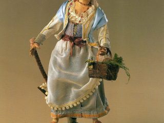 Donna vestita a festa; colori ad olio delle stoffe trattate, frutta del cestino in cera, ceramica policroma e vestitura tagliata e cucita su misura così come '700napoletano. - Pinetamare 1989 - collezione Maglione.